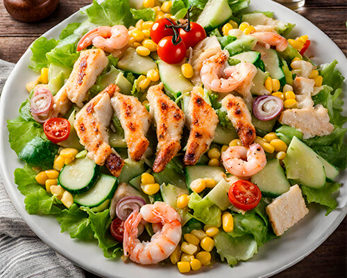 Zomerse caesarsalade met gegrilde kip en scampi